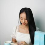 Mulher examinando frasco de produto para resenha sobre honestidade na beleza.